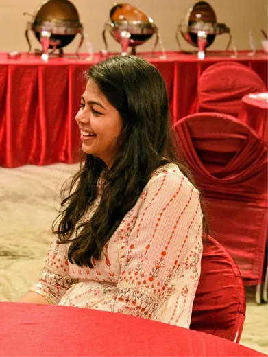 Vani at a red table